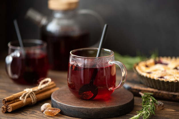 Té caliente de hibisco con canela y azúcar en una mesa de madera