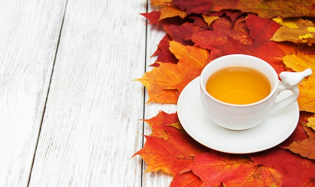 Té caliente y hojas de otoño.