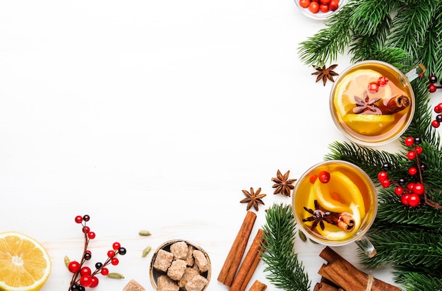 Té caliente de invierno con limón, arándanos y especias para Navidad o Año Nuevo por la noche fondo blanco espacio de copia vista superior