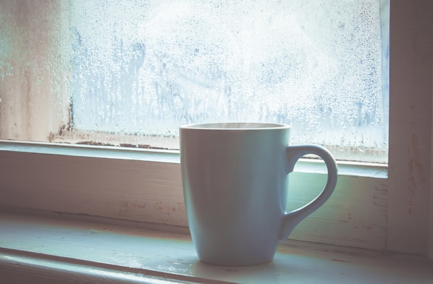 Té caliente en la olla junto a la ventana. enfoque selectivo