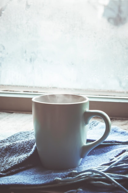 Té caliente en la olla junto a la ventana. enfoque selectivo