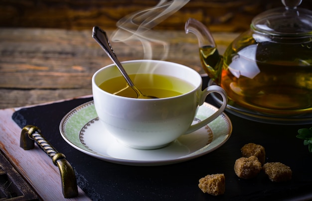 Té caliente en una taza sobre una superficie vieja