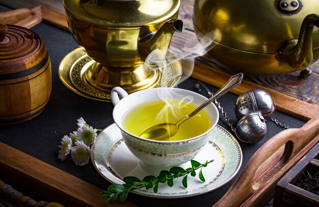 Té caliente en una taza sobre una vieja mesa.