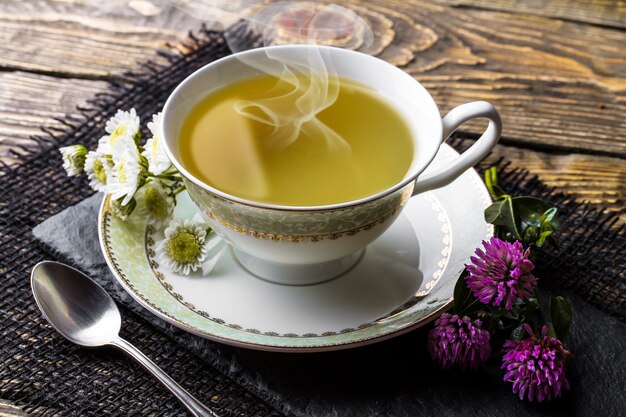 Té caliente en una taza sobre una vieja mesa.