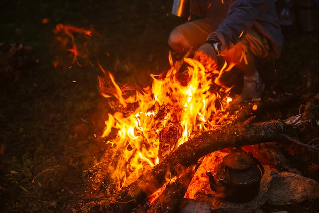 Té caliente en tetera en hoguera