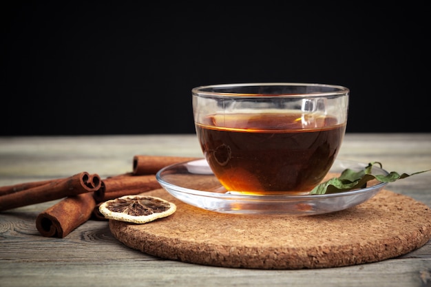 Té de canela caliente aromático en mesa de madera