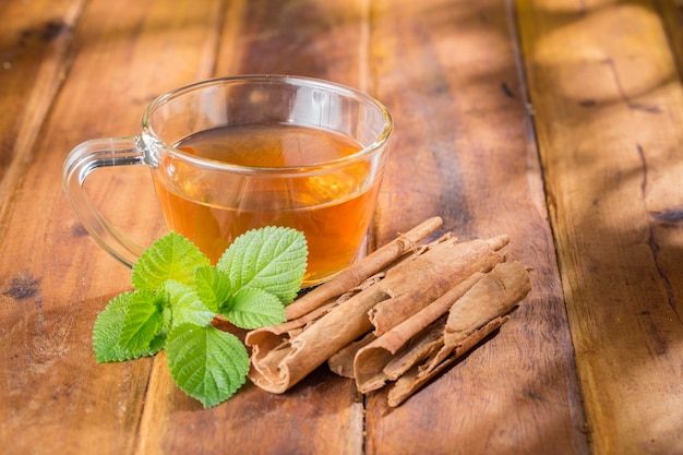 Té de canela en vaso de vidrio sobre superficie de madera libre de regalías