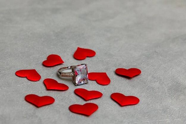 ¿Te casarías conmigo anillo de bodas muchos corazones rojos sobre fondo gris de piedra de hormigón compromiso matrimonio