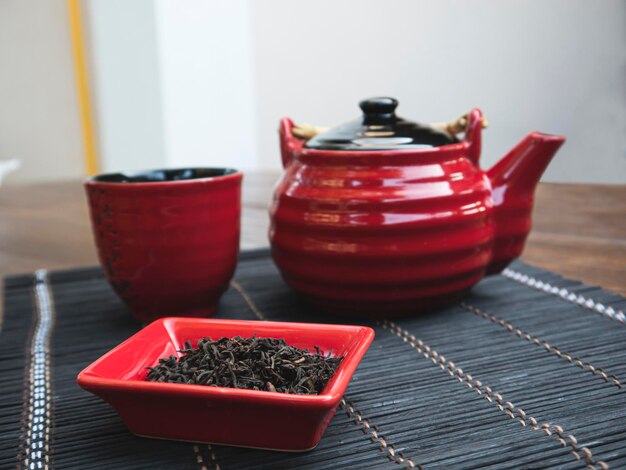 Foto té chino y una tetera roja con una taza en el bachground