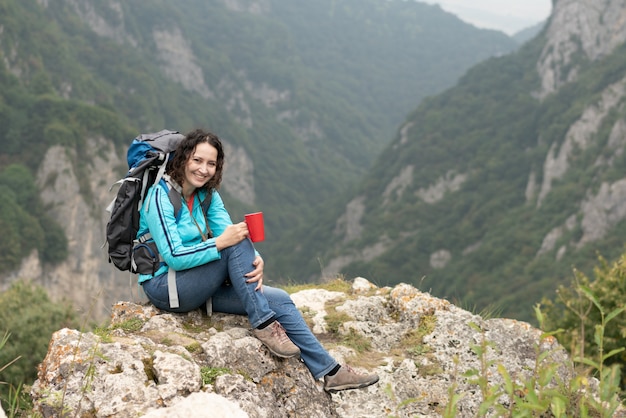 Foto té de consumición de la mujer en las montañas.