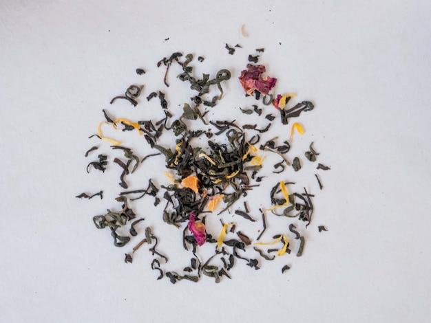 El té de diferentes hierbas se esparce en un círculo blanco.