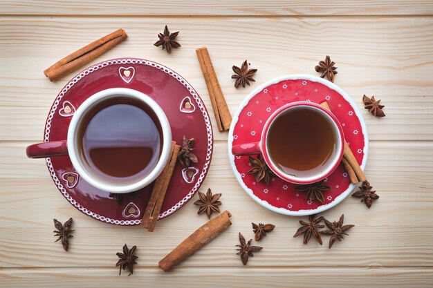 Té para dos té caliente en tazas rojas sobre mesa de madera