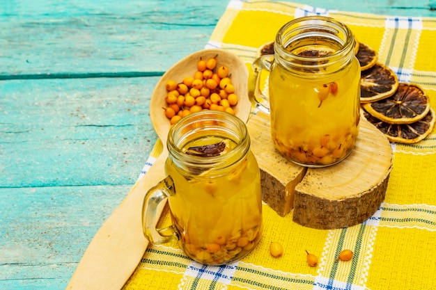 Té de espino amarillo con bayas frescas y rodajas de limón secas