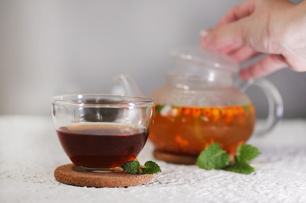 té con espino cerval de mar y menta sobre un fondo claro