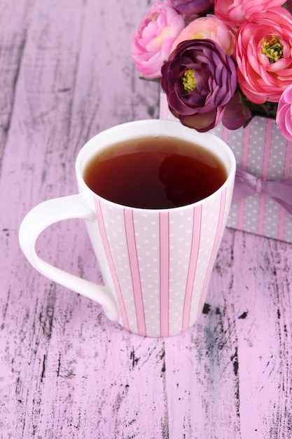 Foto té fragante con flores en un primer plano de mesa de madera