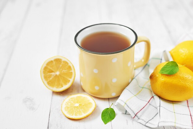 Té fresco con limón en mesa de madera