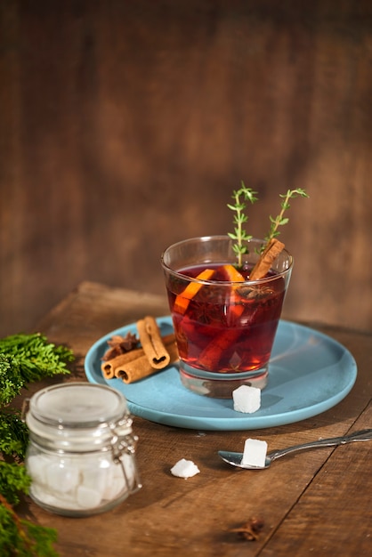 Té frío de jengibre con naranja y limón en vasos de vidrio. Té con azúcar. La decoración. Especias de canela y romero