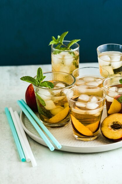 Té frío de verano con durazno y menta en vasos sobre la mesa