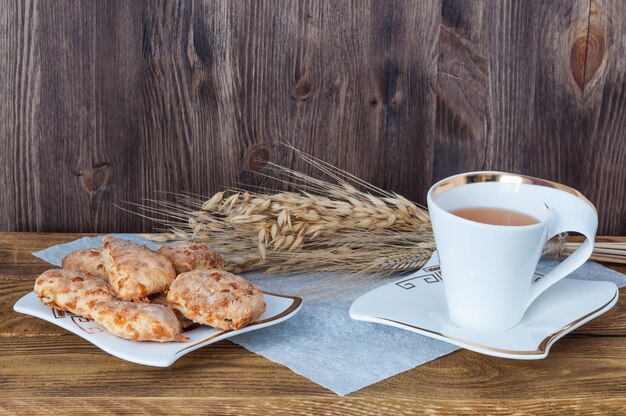 Té y galletas caseras sobre un fondo de madera.