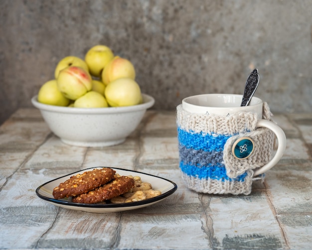 Té con galletas mermelada de galletas de avena y nueces en un plato pequeño una taza con té en un vazyanny fu