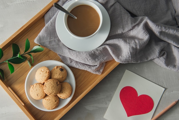 Té con galletas en plato taza blanca con postal