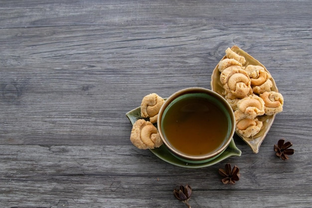 Foto té y galletas sobre fondo vintage de madera, vista superior de una taza de té con galletas, espacio de copia.