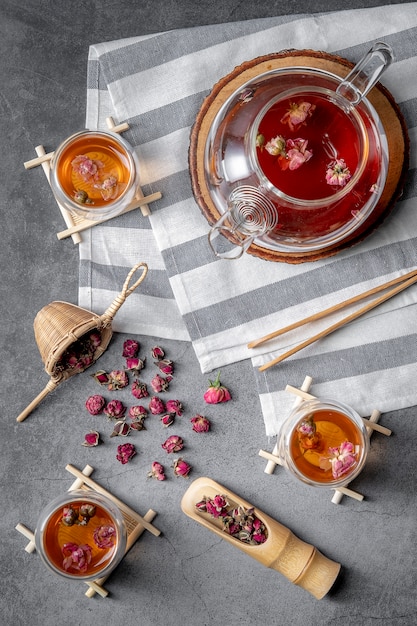 Té hecho de pétalos de rosa de té en vasos y un frasco