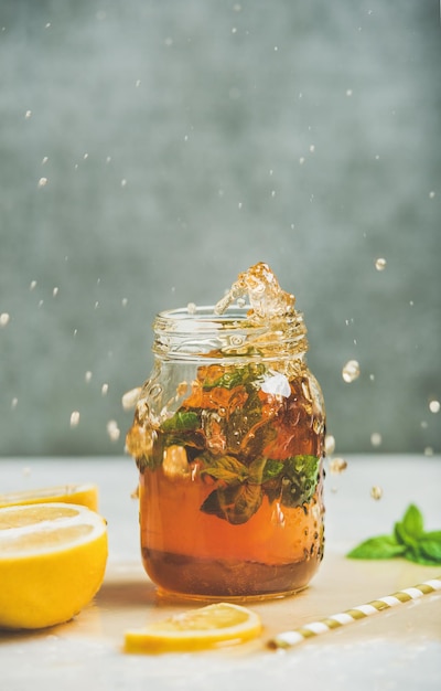 Té helado frío de verano con limón y hierbas