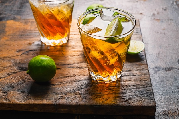 Té helado de limón y limón sobre una mesa de madera