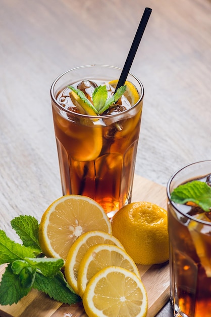 Té helado tradicional enfriado con menta limón y hielo sobre mesa rústica