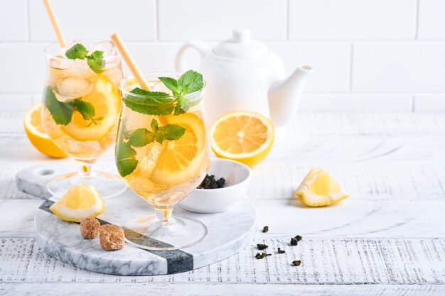 Té helado tradicional con limón y hielo en vasos altos sobre fondo de mesa de mármol Té helado con limón. Enfoque selectivo. Refresco bebida fría de verano.