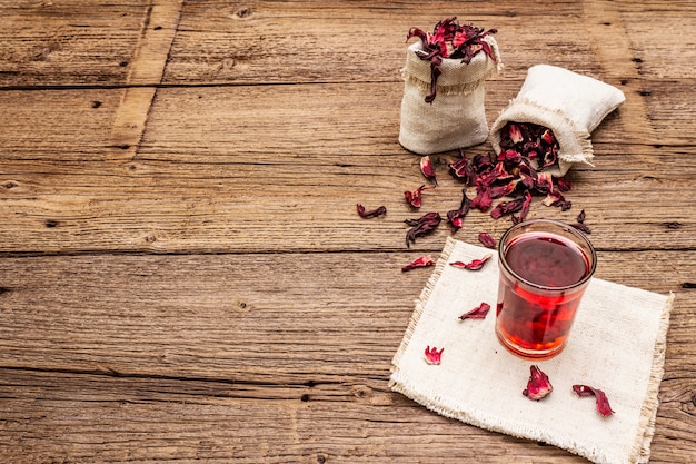 Té de hibisco caliente. Pétalos secos, sacos de lino. Comida sana y concepto de autocuidado.