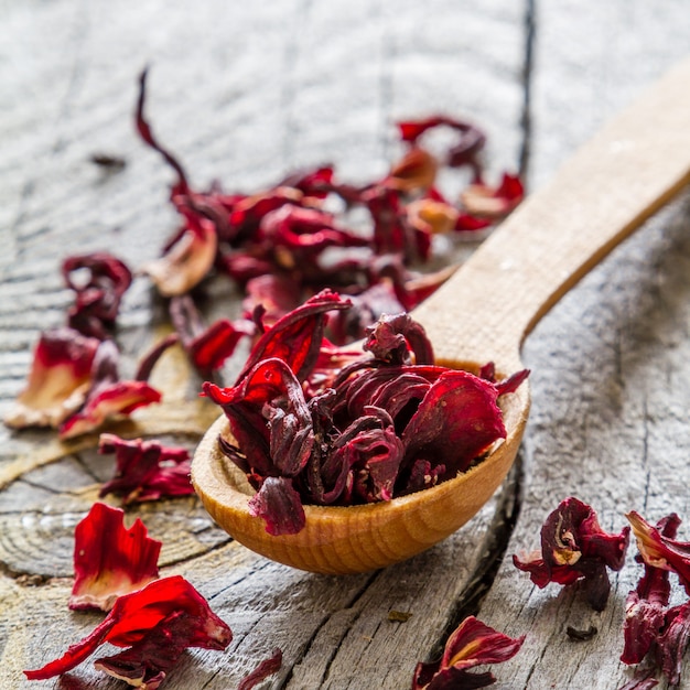 Té de hibisco seco en cuchara de madera