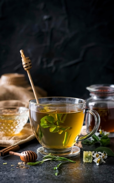 Té de hierba verde de montaña griego en taza de vidrio servido con miel y lukum en la oscuridad