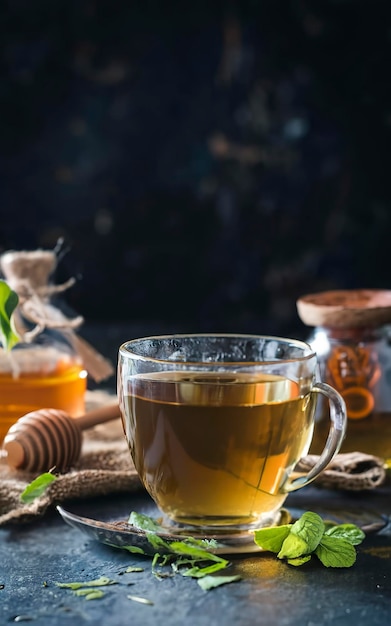 Foto té de hierba verde de montaña griego en taza de vidrio servido con miel y lukum en la oscuridad