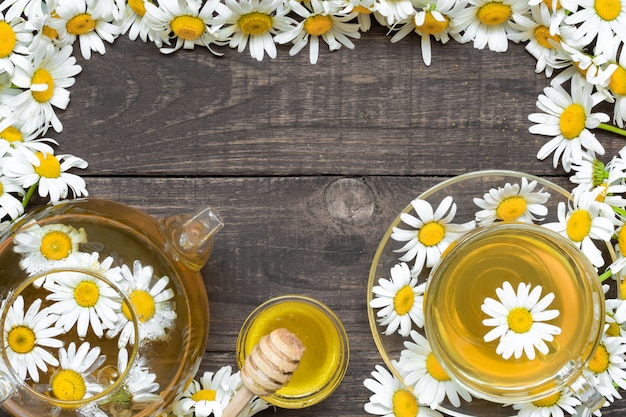 Foto té de hierbas con flores de manzanilla y miel.