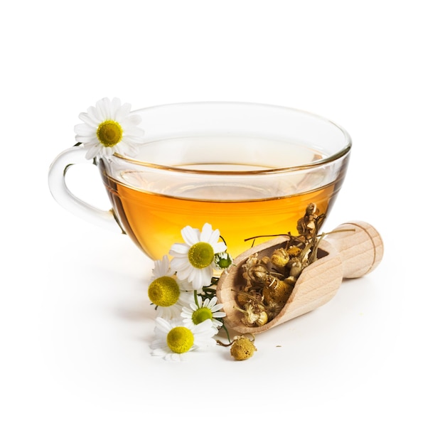 Té de hierbas con flores de manzanilla sobre fondo blanco.