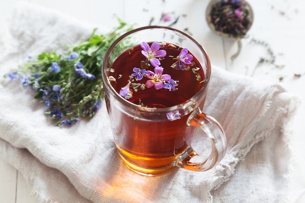 Té de hierbas con flores en vidrio transparente