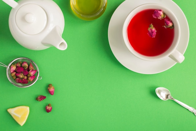 Té de hierbas con hojas de rosa rosa en la taza