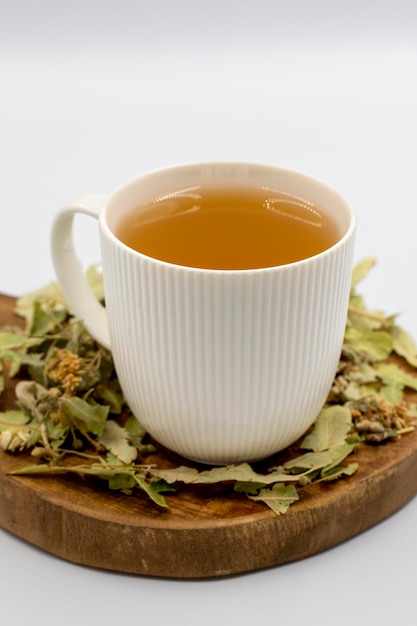 Té de hierbas de invierno aislado en un fondo blanco Té de tilo Té de hierbas inmunoestimulante Té medicinal preparado a partir de hojas de tilo Partículas de clavo y manzanilla