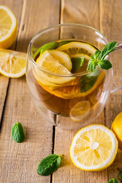 Té de hierbas con limón y menta sobre fondo de madera Deliciosa bebida para relajación y terapia alternativa de enfermedades