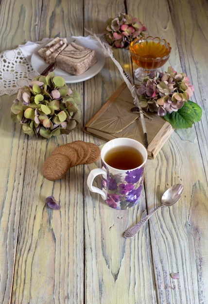 Té de hierbas en una taza de halva en un plato de galletas y miel en un primer plano de la mesa de madera