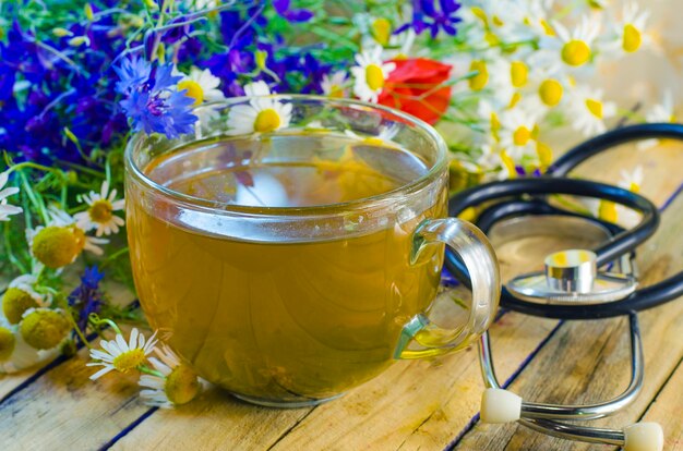 Té de hierbas útiles y medicinales y flores en una taza.