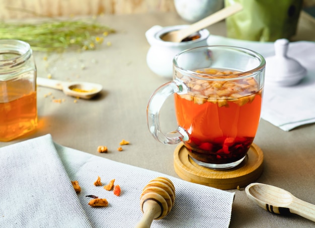 Foto té de hierbas en vaso de vidrio sobre mesa decorada