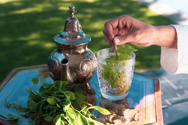 Té de hierbas verde marroquí vertido con tetera de plata en formas tradicionales