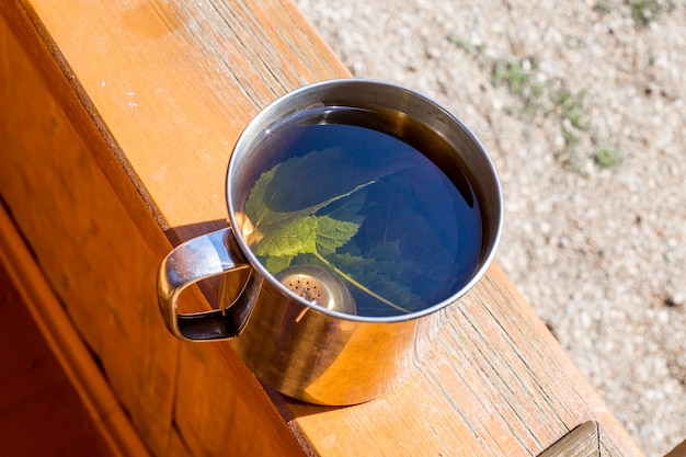 El té con hojas de grosella se elabora en una taza de metal.