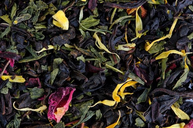 Té de hojas negras y verdes con pétalos de rosa y hierbas.