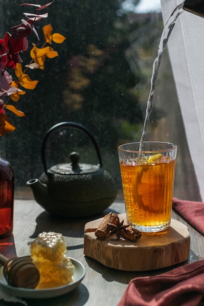 Té humeante con limón, hojas de otoño y panal