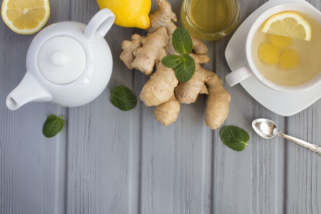 Té de jengibre e ingredientes en el fondo de madera gris. Vista superior. Copiar el espacio.