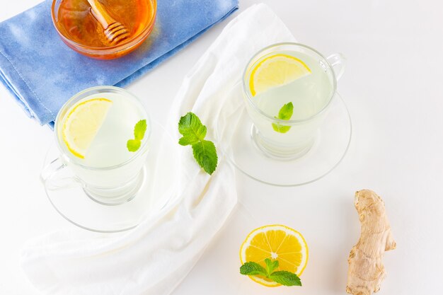 Té de jengibre con limón y menta en tazas de vidrio